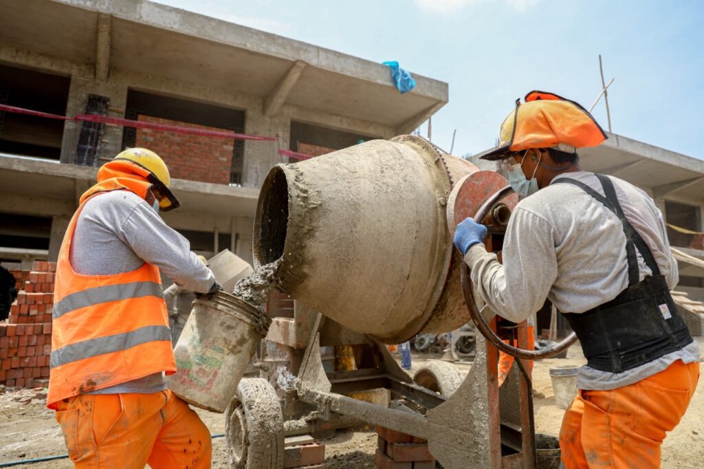 2 trabajadores de la construcción mezclando hormigón